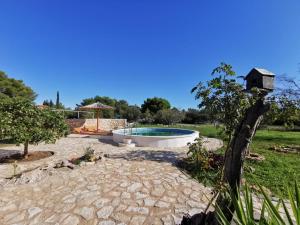 un patio trasero con piscina y una casa de aves en Hvar Mediterranean Ranch House, en Stari Grad