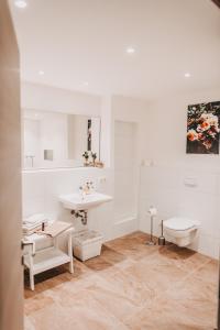 ein weißes Bad mit einem Waschbecken und einem WC in der Unterkunft THE LOFT LODGE - ATELIER in Braunschweig