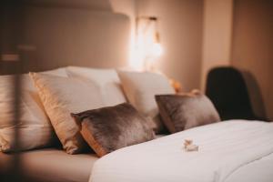 a white bed with pillows and a cat sitting on it at THE LOFT LODGE - ATELIER in Braunschweig