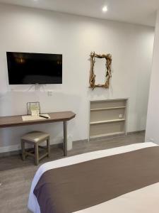 a bedroom with a desk and a mirror and a bed at Hôtel Beau Soleil in Le Lavandou