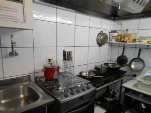 a kitchen with a sink and a stove top oven at Hostel Vergueiro in São Paulo