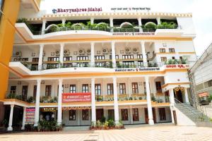 a large white building with balconies on it at Kediyoor Hotels in Udupi