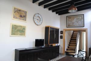 een kamer met een klok aan de muur en een tafel bij Casa de Lys in Sanlúcar de Barrameda