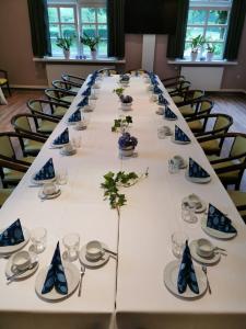 einem langen Tisch mit Tellern und Geschirr darauf in der Unterkunft Gasthaus Block in Harkebrügge