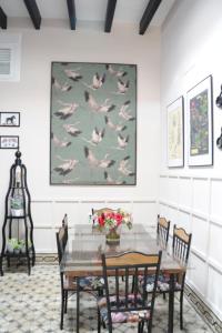 een eetkamer met een tafel met vogels aan de muur bij Casa de Lys in Sanlúcar de Barrameda +9 foto's