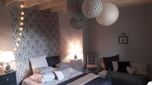 1 dormitorio con cama, silla y luces en Cœur de vigne à Colombier 24560 en Issigeac