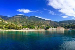 a view of a body of water with mountains in the background at Hôtel Beau Soleil in Le Lavandou