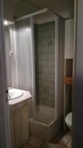 een badkamer met een douche, een wastafel en een toilet bij SUN in Portiragnes