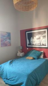 um quarto com uma cama azul com um quadro na parede em Domaine Sesquier Mas d'exception Pivoine em Mèze