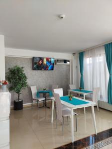 un salon avec des tables, des chaises et une télévision dans l'établissement Armsea Mamaia Nord, à Mamaia Nord – Năvodari