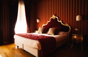 um quarto com uma cama grande e uma parede vermelha em Murano Palace em Murano