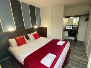 1 dormitorio con 1 cama grande con almohadas rojas y blancas en Fasthotel Tours Nord, en Parçay-Meslay