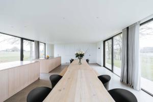 - une grande table en bois dans une chambre avec fenêtres dans l'établissement Woodhouse94, à Zonnebeke