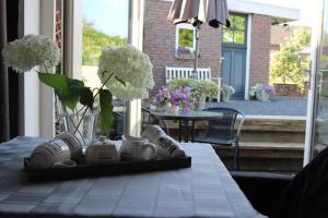 a table with a tray with shoes and flowers on it at Slapen & Smullen in Swalmen