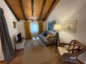 a living room with a couch and a tv at Casa Olivia - Charming renovated farmhouse with panoramic views in Tavira