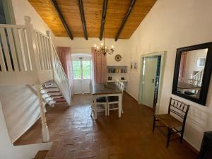 a room with a staircase and a table and chairs at Casa Olivia - Charming renovated farmhouse with panoramic views in Tavira