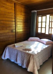 een slaapkamer met een bed in een kamer met een raam bij Chalé Vista da Mata DM, 5km Centro Domingos Martins, Wi Fi, fibra óptica, SPA aquecido, split, privacidade, aceita pets in Domingos Martins