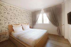 a bedroom with a bed with white sheets and a window at Villa Eliza in Denia +49 photos