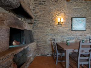 a dining room with a table and a stone wall at Casa Blanco in Palas de Rei