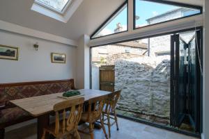 a dining room with a table and a large window at Church View Cottage in Kendal
