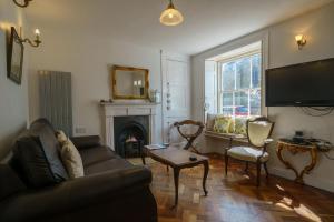 a living room with a couch and a fireplace at Church View Cottage in Kendal