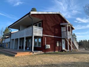 een rode schuur met een veranda en een terras bij Rämsbyns fritidsby in Idkerberget