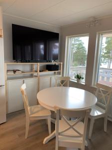 a kitchen with a table and chairs and a tv at Rämsbyns fritidsby in Idkerberget
