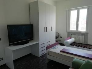 uma sala de estar com uma televisão e um sofá em ORIZZONTE SUL MARE em Savona