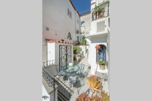 a balcony with a table and chairs on a building at Casa Vacanza Al Centro di Capri in Capri