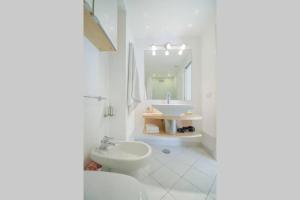 a white bathroom with a sink and a toilet at Casa Vacanza Al Centro di Capri in Capri
