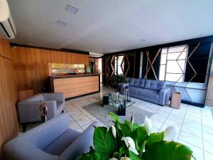 a living room with blue couches and a table at One Hotel in João Pessoa