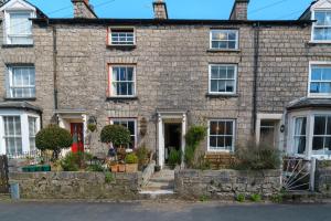 an old stone house with a red door at Church View Cottage in Kendal