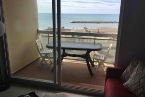 a table and chairs on a balcony with a view of the beach at T3 vue exceptionnelle avec accès privé à la plage, wifi, clim - dansnotreappart-com - in Valras-Plage