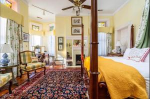 Burke Mansion في ماكون: غرفة نوم مع سرير المظلة ومدفأة