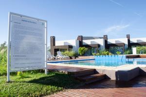 a sign next to a swimming pool in front of a building at Amanzi Termal Rental in Concordia