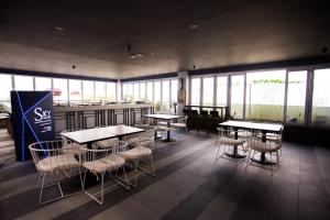 a restaurant with tables and chairs in a room with windows at Suasana suites By The one in Johor Bahru