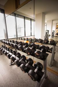 a row of dumbbells in a gym with a mirror at Suasana suites By The one in Johor Bahru
