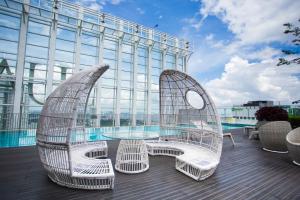 two white chairs and a glass table on a balcony at Suasana suites By The one in Johor Bahru