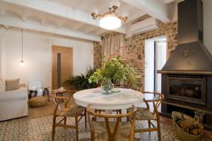 a living room with a table and chairs and a fireplace at L'Hostatgeria del Celler in Porrera