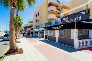 a street with a palm tree and a building at Apartamento COSTAMARINA in Cabo Roig