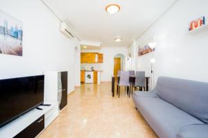 Apartamento COSTAMARINA في كابو رويج: غرفة معيشة مع أريكة وتلفزيون