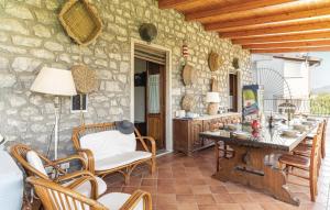 cocina con mesa, sillas y pared de piedra en Dimora Villa Rita en Acquavena