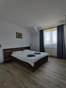 sypialnia z dużym łóżkiem i dużym oknem w obiekcie Pensiunea Roua w mieście Piatra Neamţ
