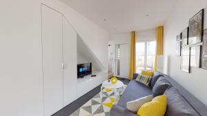 een woonkamer met een bank en een tv bij PARIS HOUSE in Villejust