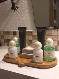 three bottles of moisturizers on a wooden tray on a counter at Moselina Gästezimmer in Sankt Aldegund +69 photos