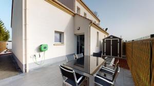 a patio with a table and chairs and a fence at PARIS HOUSE in Villejust