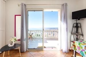 um quarto com uma porta de vidro deslizante que leva a uma varanda em Observatoire em Nice