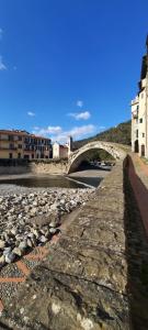un puente de piedra sobre un río con rocas en La Gallina Nel Castello Citr oo9002-beb oo11, en Albenga