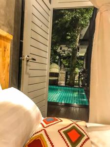 a bedroom with a view of a swimming pool through a door at Exclusive access to the whole garden. in Bangkok
