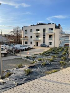 un gran edificio con coches estacionados en un estacionamiento en Apartamenty Bartnicza C, en Bielsko-Biala